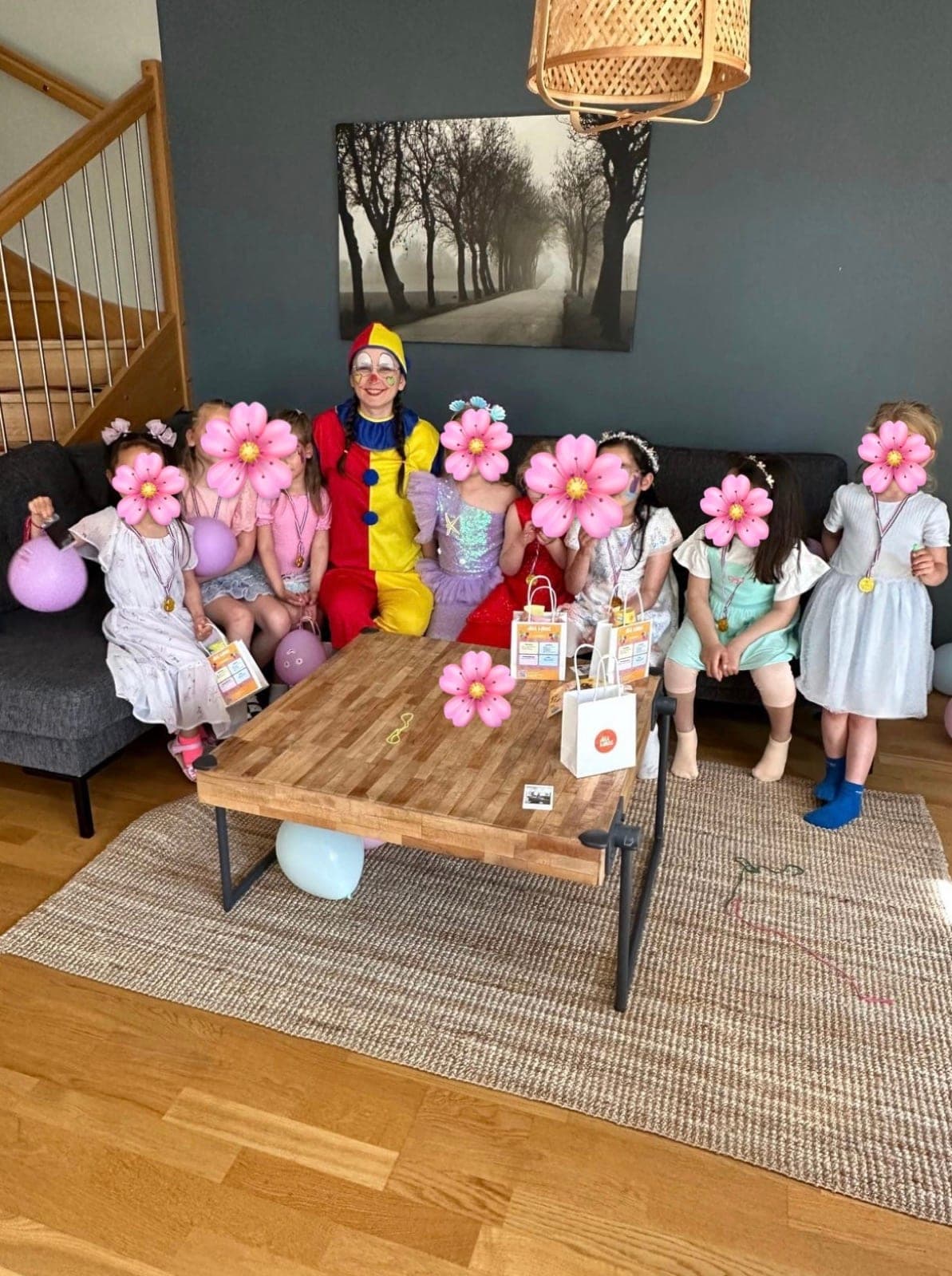 Lekledare utklädd till clown tillsammans med barnen på kalaset