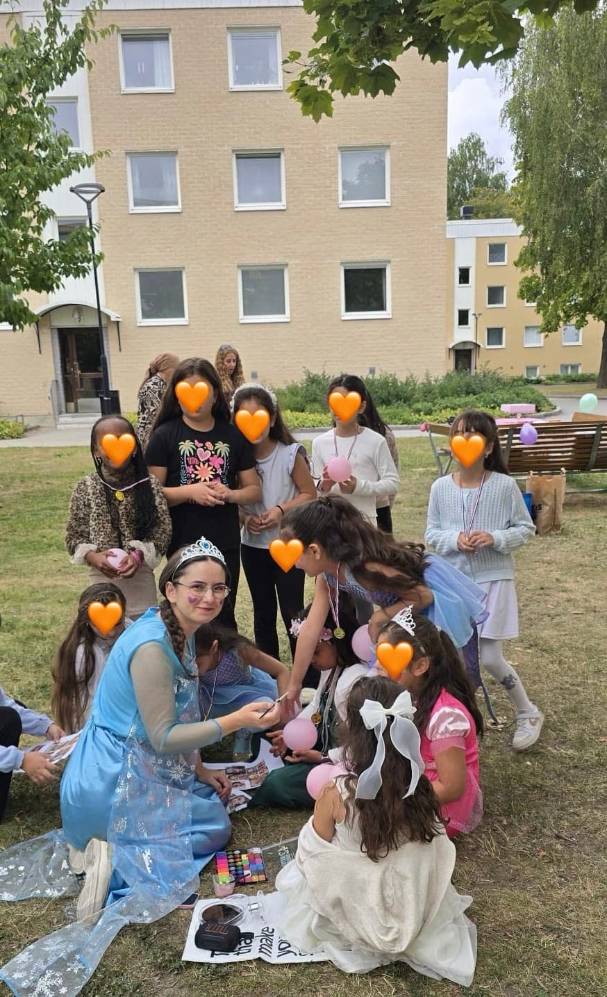Lekledare utklädd till Elsa som ansiktsmålar barn på kalaset